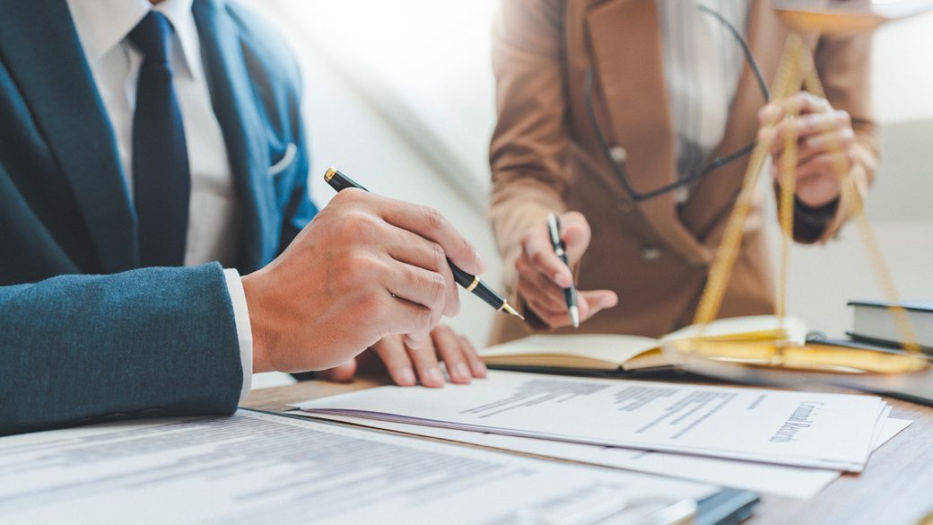 Two people holding pens working together